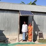 Ehepaar mit Solar-Panel am Haus