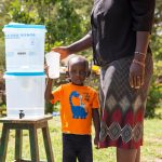 Kind an einer Wasserfilterstation in Kenya